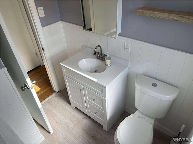 90 Nadon Pl, Tonawanda-Town, NY 14150 - bathroom with wood finished floors, vanity, toilet, a wainscoted wall, and a decorative wall