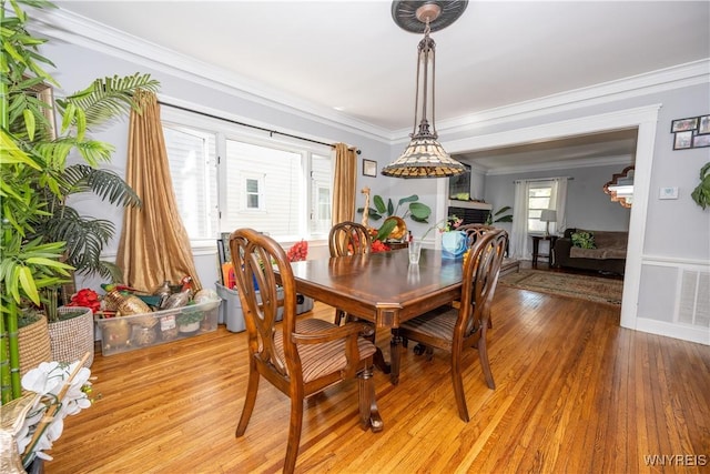 47 Winston Rd, Buffalo, NY 14216 - dining room featuring crown molding, light wood-type flooring, and a fireplace