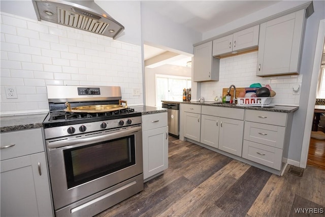 47 Winston Rd, Buffalo, NY 14216 - kitchen with appliances with stainless steel finishes, wall chimney exhaust hood, decorative backsplash, a sink, and dark wood finished floors