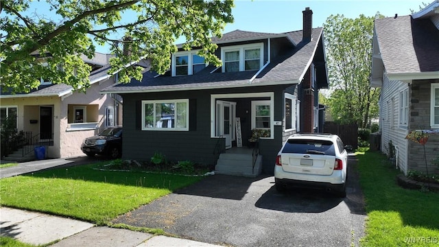 47 Winston Rd, Buffalo, NY 14216 - bungalow featuring a chimney, a front lawn, and roof with shingles