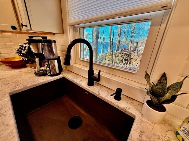 8119 Martin Rd, Wolcott, NY 14590 - kitchen view of a sink, tasteful backsplash, and light stone countertops