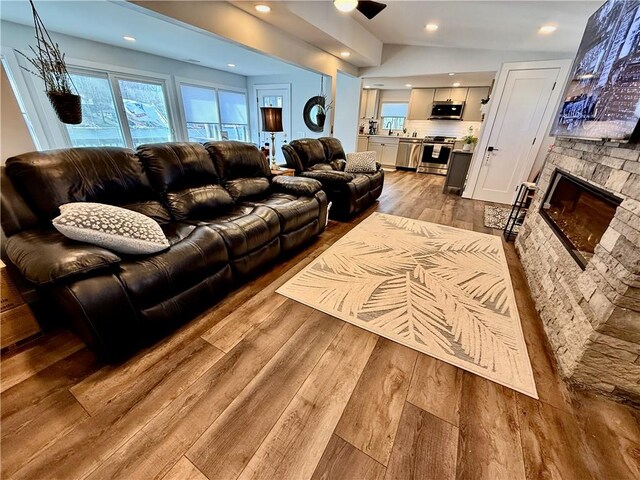 8119 Martin Rd, Wolcott, NY 14590 - living room featuring wood-type flooring, a stone fireplace, recessed lighting, and ceiling fan