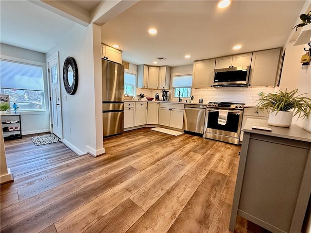 8119 Martin Rd, Wolcott, NY 14590 - kitchen with appliances with stainless steel finishes, light wood-style flooring, backsplash, recessed lighting, and baseboards