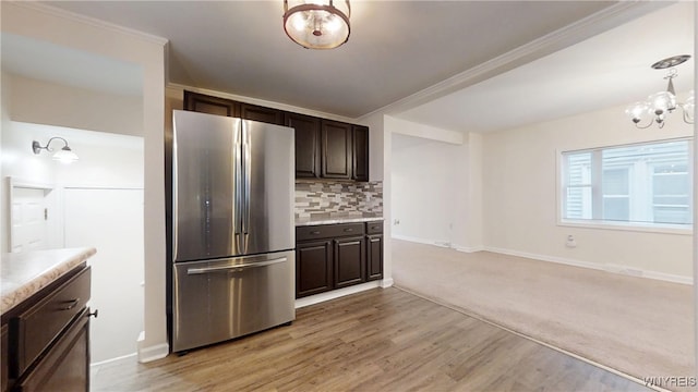 524 Lasalle Ave, Buffalo, NY 14215 - kitchen featuring freestanding refrigerator, dark brown cabinetry, a chandelier, tasteful backsplash, and ornamental molding