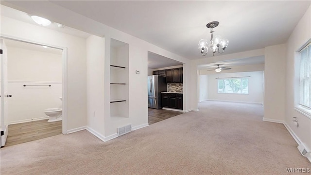 524 Lasalle Ave, Buffalo, NY 14215 - unfurnished living room featuring light carpet, a chandelier, baseboards, and a ceiling fan