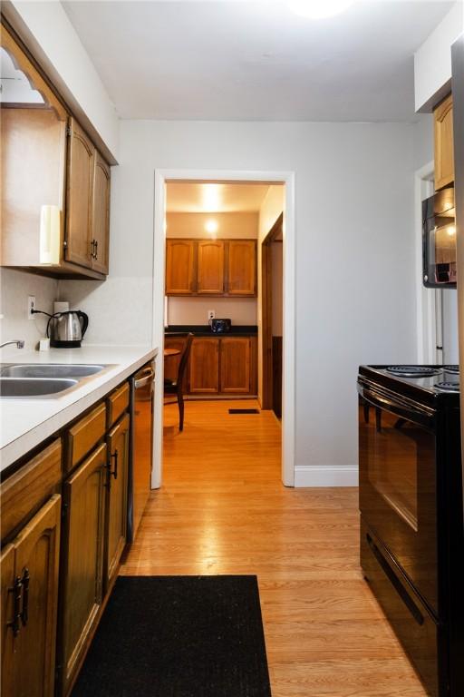 182 E Pulteney St, Corning City, NY 14830 - kitchen featuring black appliances, a sink, light wood finished floors, brown cabinetry, and light countertops