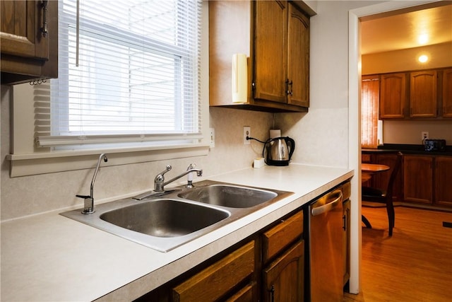 182 E Pulteney St, Corning City, NY 14830 - kitchen featuring a sink, stainless steel dishwasher, wood finished floors, light countertops, and brown cabinetry
