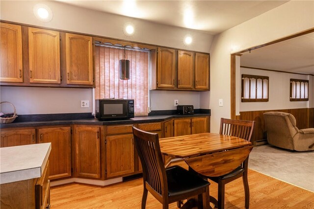 182 E Pulteney St, Corning City, NY 14830 - kitchen featuring black microwave, brown cabinetry, light wood-style flooring, open floor plan, and dark countertops