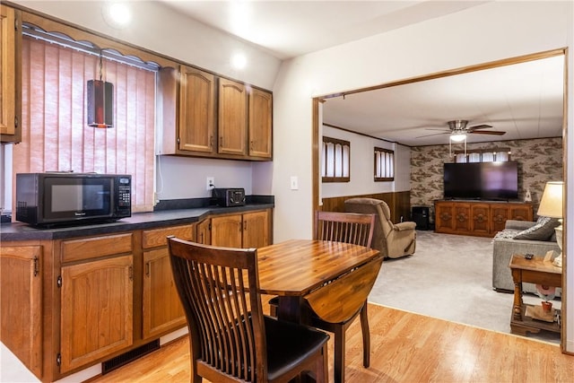 182 E Pulteney St, Corning City, NY 14830 - kitchen featuring black microwave, ceiling fan, dark countertops, light wood-type flooring, and wallpapered walls