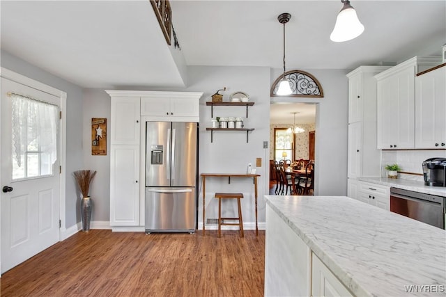 7263 Quaker Rd, Orchard Park, NY 14127 - kitchen with stainless steel appliances, wood finished floors, white cabinets, and baseboards