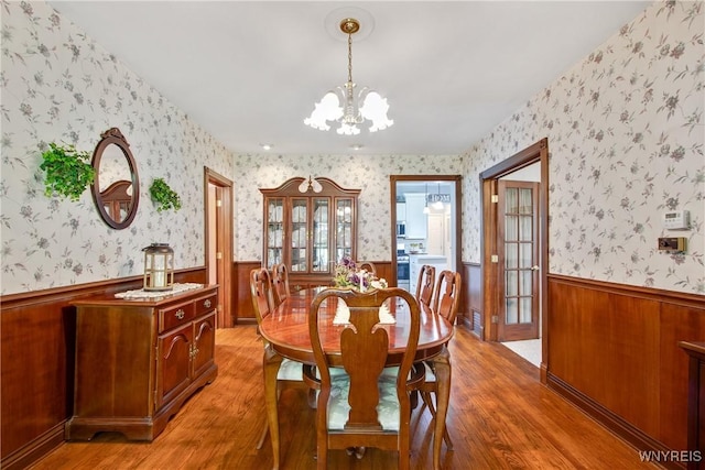 7263 Quaker Rd, Orchard Park, NY 14127 - dining space featuring a wainscoted wall, a chandelier, light wood finished floors, and wallpapered walls
