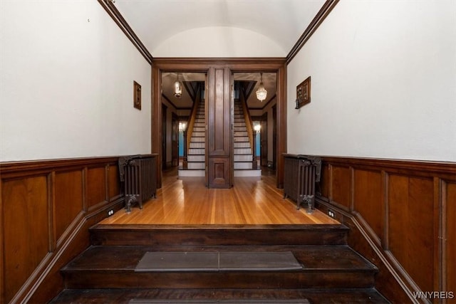 2884 Main St, Buffalo, NY 14214 - staircase featuring wood finished floors, vaulted ceiling, and wainscoting