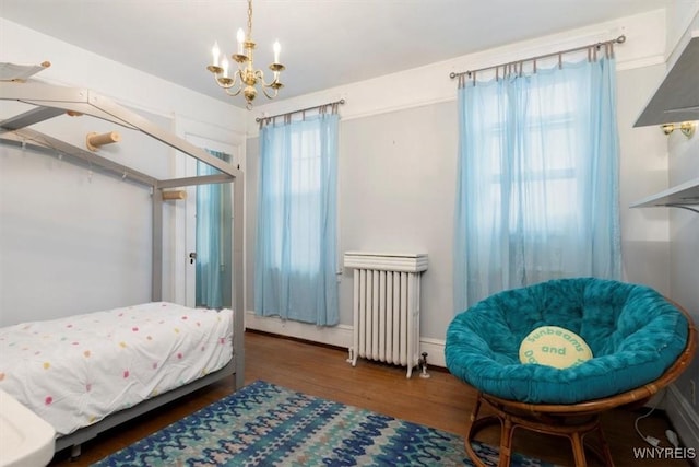 2884 Main St, Buffalo, NY 14214 - bedroom featuring radiator, a chandelier, and wood finished floors