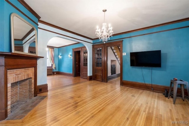2884 Main St, Buffalo, NY 14214 - unfurnished living room featuring a chandelier, crown molding, wood finished floors, and baseboards