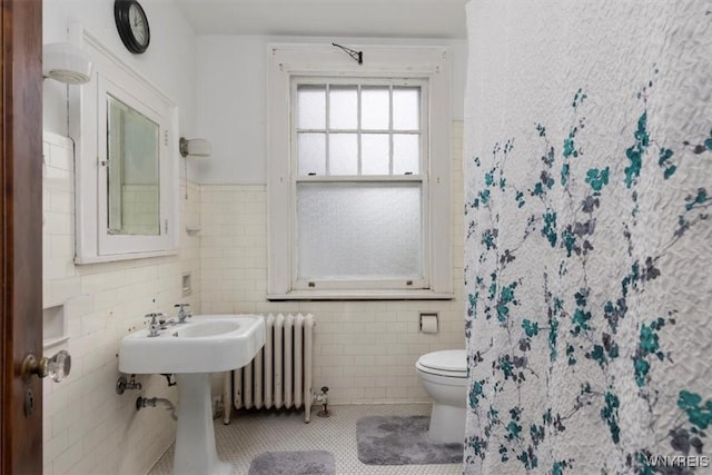 2884 Main St, Buffalo, NY 14214 - full bath featuring radiator, tile walls, toilet, tile patterned flooring, and wainscoting