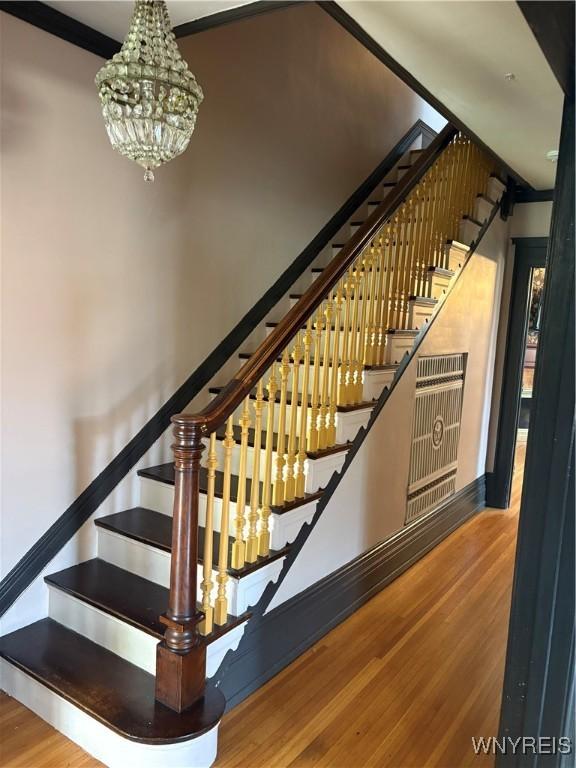 2884 Main St, Buffalo, NY 14214 - stairway featuring wood finished floors and a chandelier
