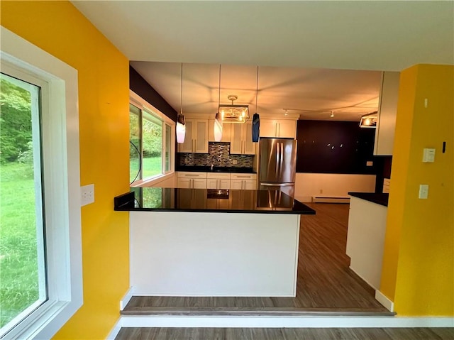 1302 Swart Rd, Middletown, NY 12455 - kitchen featuring freestanding refrigerator, dark countertops, a baseboard radiator, a peninsula, and dark wood-style floors