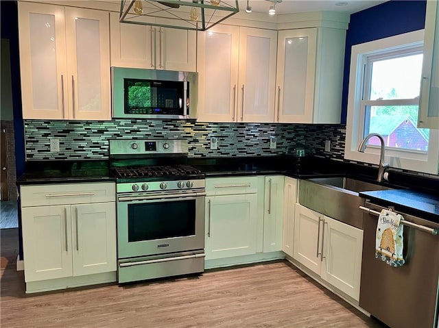 1302 Swart Rd, Middletown, NY 12455 - kitchen with stainless steel appliances, dark countertops, backsplash, and light wood-type flooring