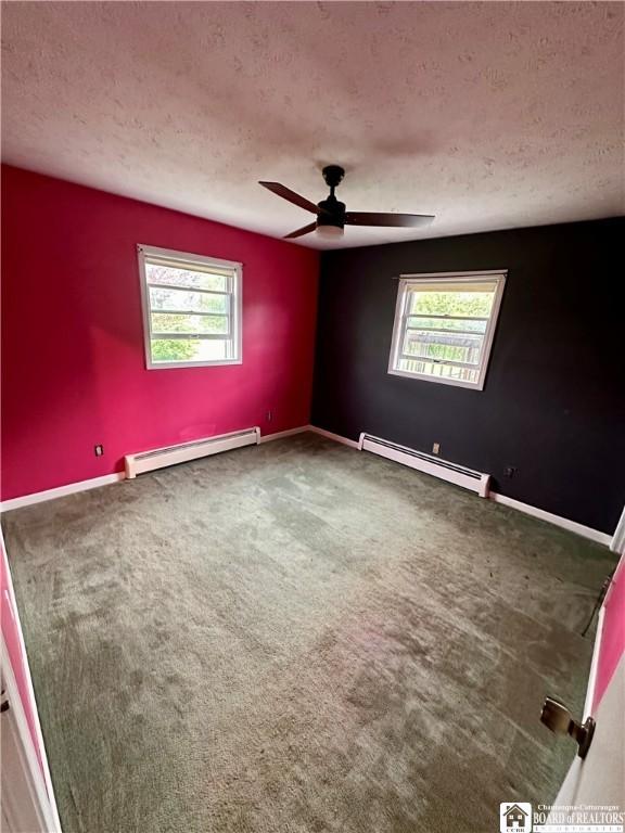 538 Erie St, Olean-City, NY 14760 - spare room with baseboard heating, a textured ceiling, carpet floors, and ceiling fan