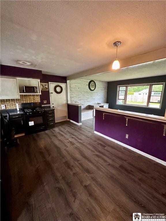 538 Erie St, Olean-City, NY 14760 - unfurnished living room featuring a textured ceiling, dark wood-style floors, and baseboards
