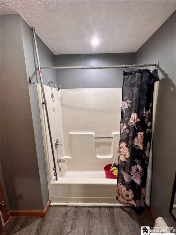 538 Erie St, Olean-City, NY 14760 - bathroom featuring wood finished floors, a textured ceiling, shower / bath combo, and baseboards