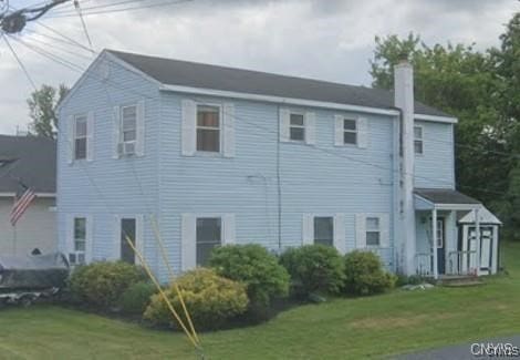 7090 Lakeshore Rd, Cicero, NY 13039 - view of side of home featuring a chimney and a lawn