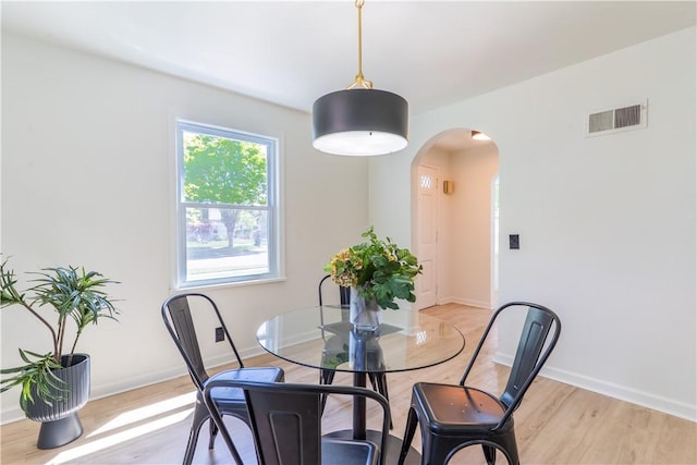 22 Idyllwood Ln, Irondequoit, NY 14617 - dining area with arched walkways, light wood finished floors, and baseboards