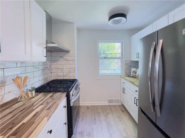 22 Idyllwood Ln, Irondequoit, NY 14617 - kitchen with freestanding refrigerator, gas stove, white cabinetry, tasteful backsplash, and light countertops