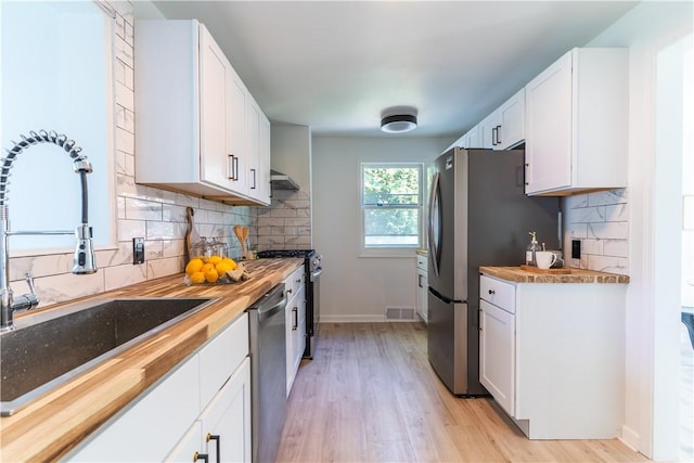 22 Idyllwood Ln, Irondequoit, NY 14617 - kitchen featuring a sink, light wood-type flooring, stainless steel appliances, butcher block countertops, and white cabinets