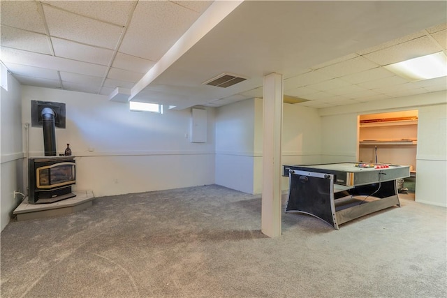 82 Haskins Ln N, Greece, NY 14468 - below grade area featuring a paneled ceiling, a wood stove, and carpet floors