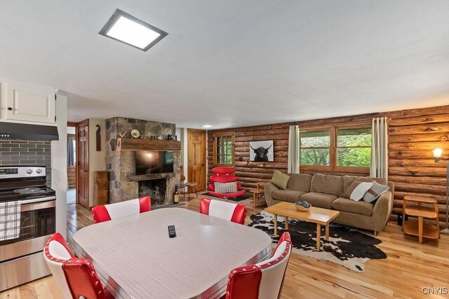 4090 Old Kennedy Rd, Onondaga, NY 13120 - dining area with rustic walls, light wood-type flooring, and a fireplace