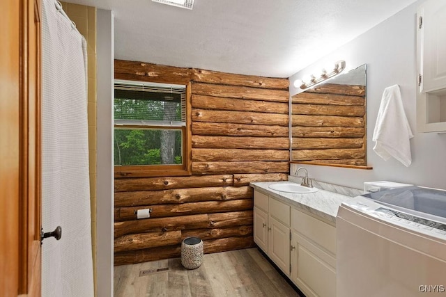 4090 Old Kennedy Rd, Onondaga, NY 13120 - full bathroom featuring rustic walls, washer / clothes dryer, vanity, and wood finished floors