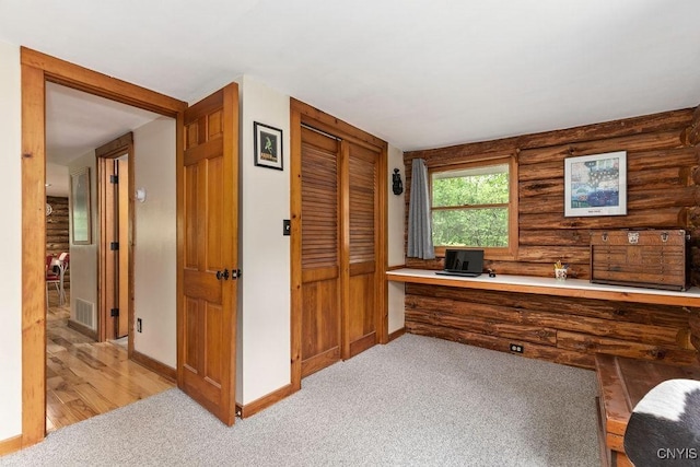 4090 Old Kennedy Rd, Onondaga, NY 13120 - office featuring built in desk, log walls, light carpet, and baseboards