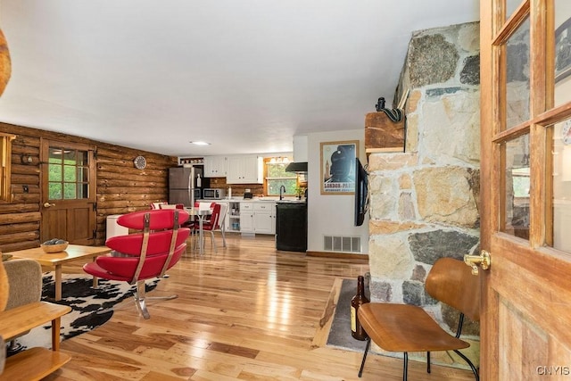 4090 Old Kennedy Rd, Onondaga, NY 13120 - living room featuring rustic walls, plenty of natural light, and light wood-type flooring