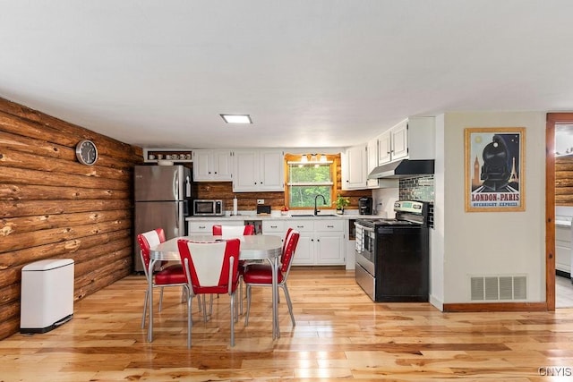 4090 Old Kennedy Rd, Onondaga, NY 13120 - kitchen with appliances with stainless steel finishes, under cabinet range hood, log walls, light countertops, and light wood-style flooring