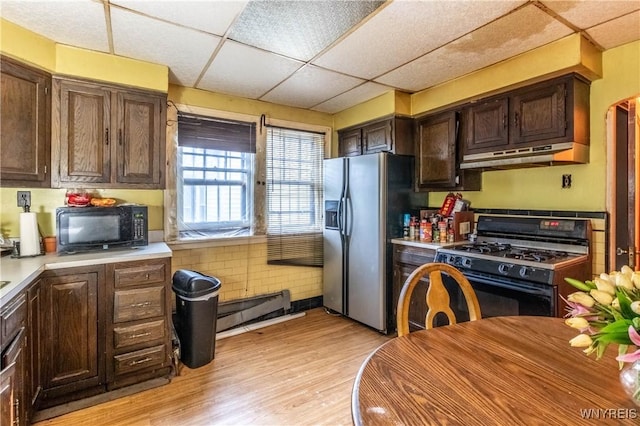 49 Mercer Ave, Buffalo, NY 14214 - kitchen featuring range with gas cooktop, stainless steel fridge, under cabinet range hood, black microwave, and baseboard heating
