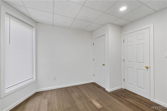123 6th St, Niagara Falls, NY 14303 - unfurnished bedroom featuring dark wood-style flooring, a paneled ceiling, and baseboards