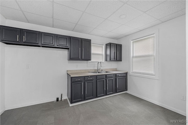 123 6th St, Niagara Falls, NY 14303 - kitchen with a sink, a paneled ceiling, light countertops, baseboards, and dark cabinetry