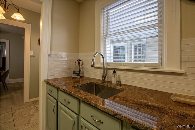 624 Buffalo Ave, Niagara Falls, NY 14303 - kitchen featuring green cabinetry, a sink, healthy amount of natural light, and backsplash