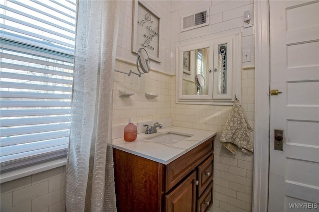 624 Buffalo Ave, Niagara Falls, NY 14303 - bathroom with tile walls, vanity, and decorative backsplash