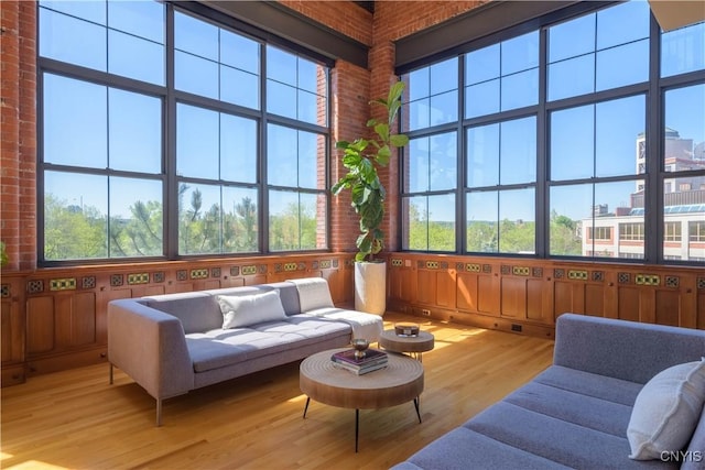 526 Plum St Unit 408, Syracuse, NY 13204 - sunroom featuring wood finished floors, a deck, a high ceiling, and brick wall