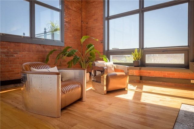 526 Plum St Unit 408, Syracuse, NY 13204 - living area with brick wall and wood finished floors