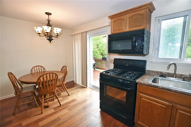 414 Fox Run, Gates, NY 14606 - kitchen with black appliances, a sink, a chandelier, wood finished floors, and dark countertops