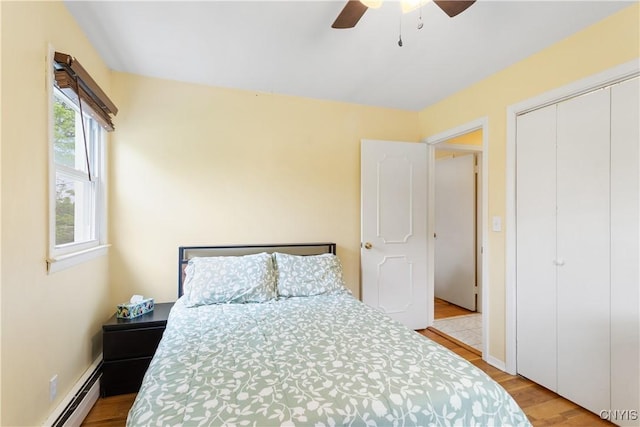 27 Cascade Dr, New Hartford, NY 13413 - bedroom featuring baseboard heating, light wood-style flooring, a ceiling fan, and a closet