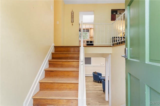 27 Cascade Dr, New Hartford, NY 13413 - staircase with wood finished floors and a baseboard radiator