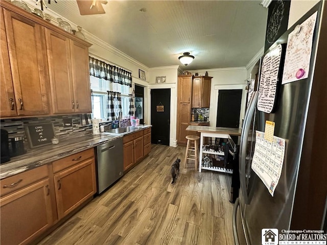 223 S 7th St, Olean-City, NY 14760 - kitchen featuring stainless steel appliances, a sink, brown cabinetry, wood finished floors, and crown molding