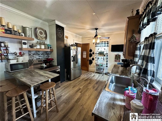 223 S 7th St, Olean-City, NY 14760 - kitchen with appliances with stainless steel finishes, a sink, ornamental molding, a ceiling fan, and wood finished floors