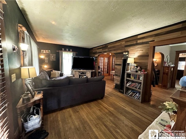 223 S 7th St, Olean-City, NY 14760 - living area with arched walkways, wood walls, wood finished floors, and a textured ceiling