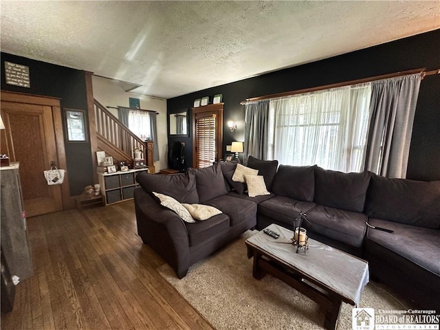 223 S 7th St, Olean-City, NY 14760 - living area featuring a textured ceiling, dark wood-style flooring, and stairway