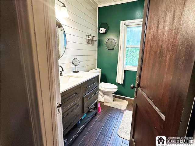 223 S 7th St, Olean-City, NY 14760 - bathroom featuring wood walls, vanity, toilet, wood finished floors, and baseboards